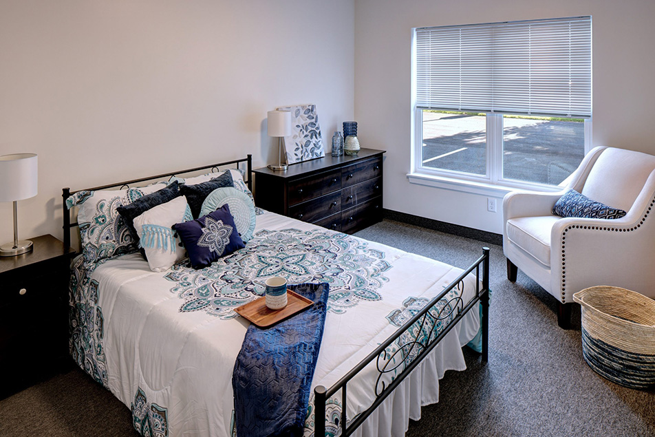 photo of a bedroom with blue and white bed spread and pillows