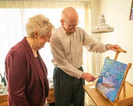 two seniors looking at a painting